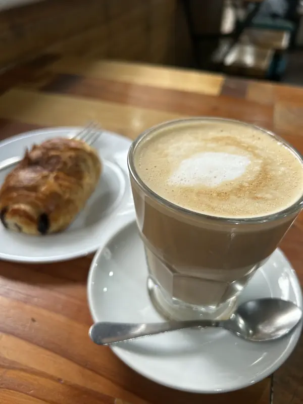 Café con leche en vaso y un pan con chocolate